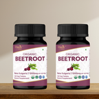 Two bottles of Organic Beetroot supplement on a wooden surface with a beige background